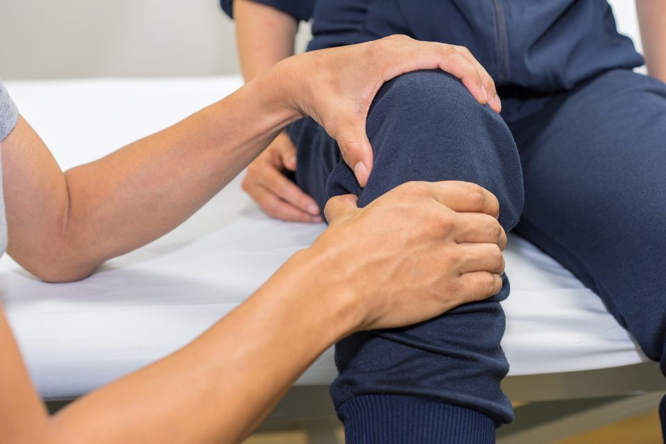 a chiropractor is performing a treatment on a patient's knee pain